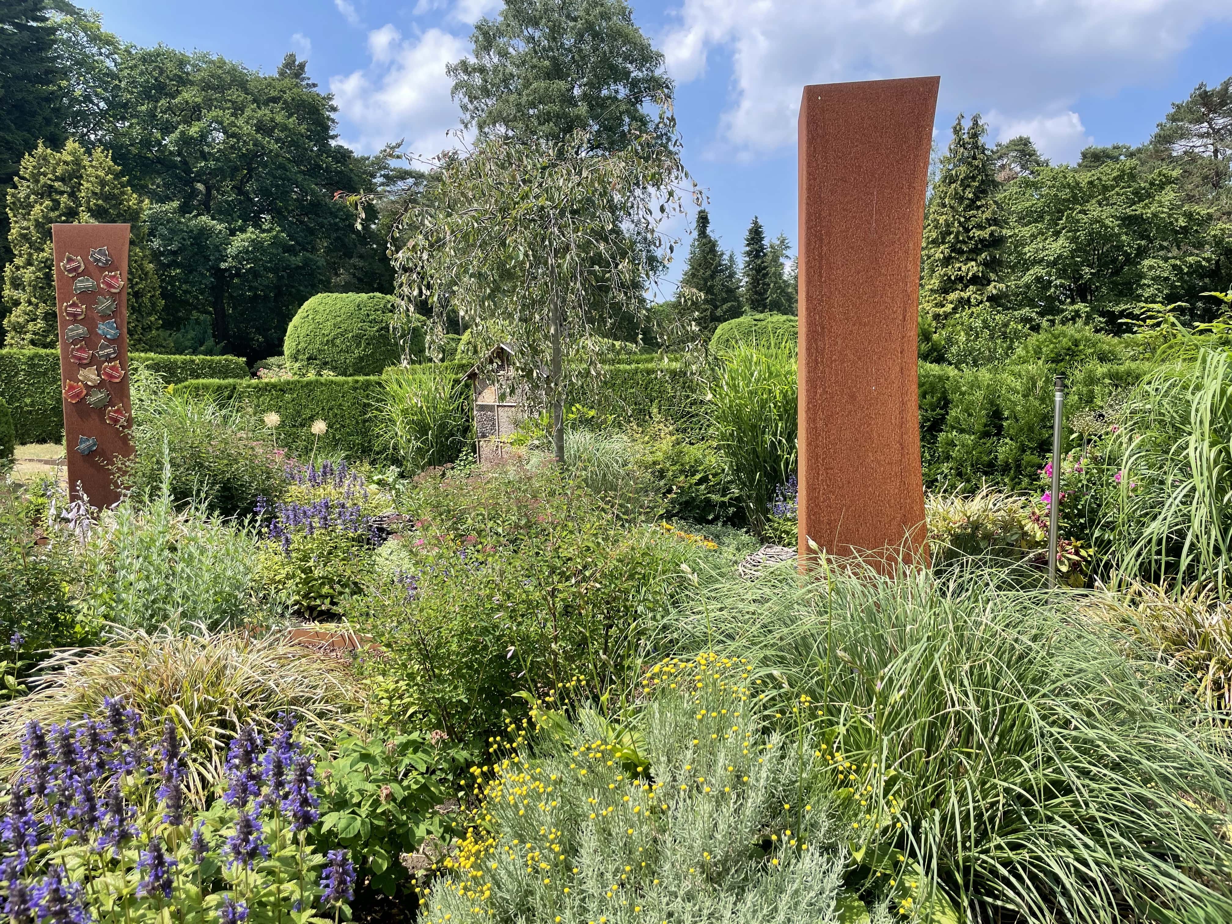 Staudengarten im Juni mit Grabmal